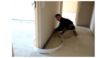 Installation d’un plancher chauffant électrique: pose et raccordement autour d’un renfort de mur lors d’un chantier.