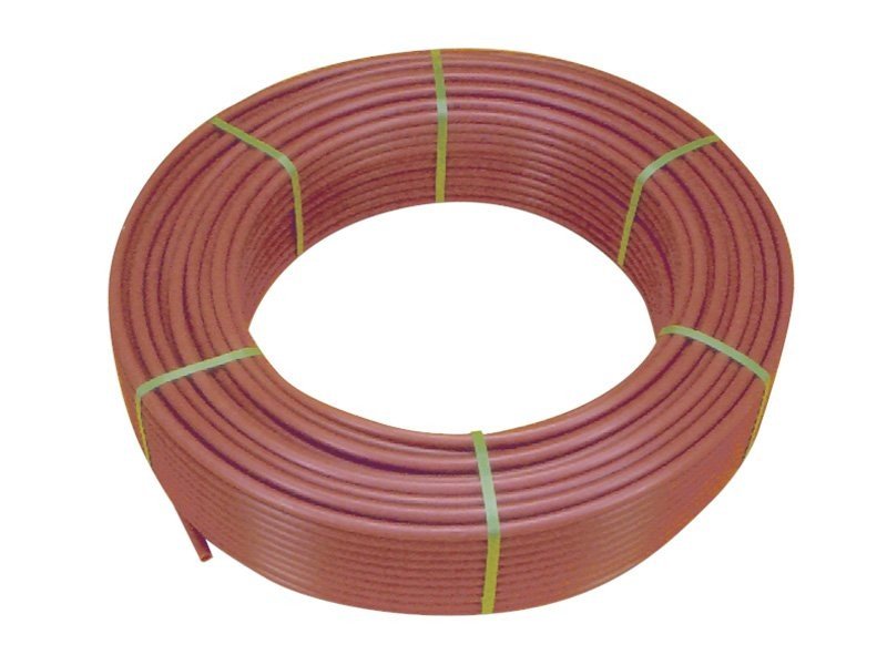 Origine du plancher chauffant hydraulique principe de fonctionnement : bobine de tuyau rouge souple prête à être installée sous le sol pour diffusion de chaleur par eau chaude.